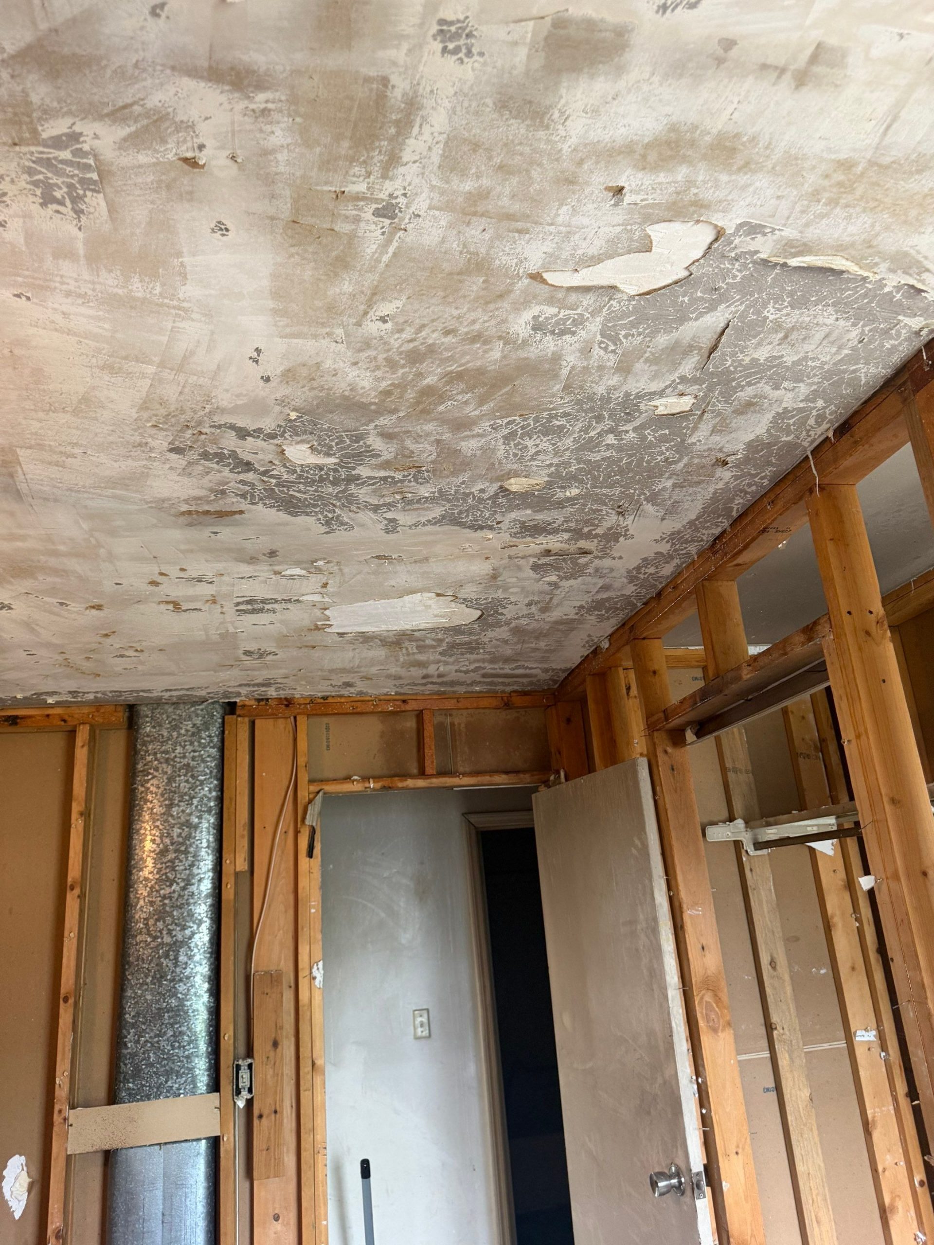 Fire-damaged ceiling with heavy soot and peeling paint in a home