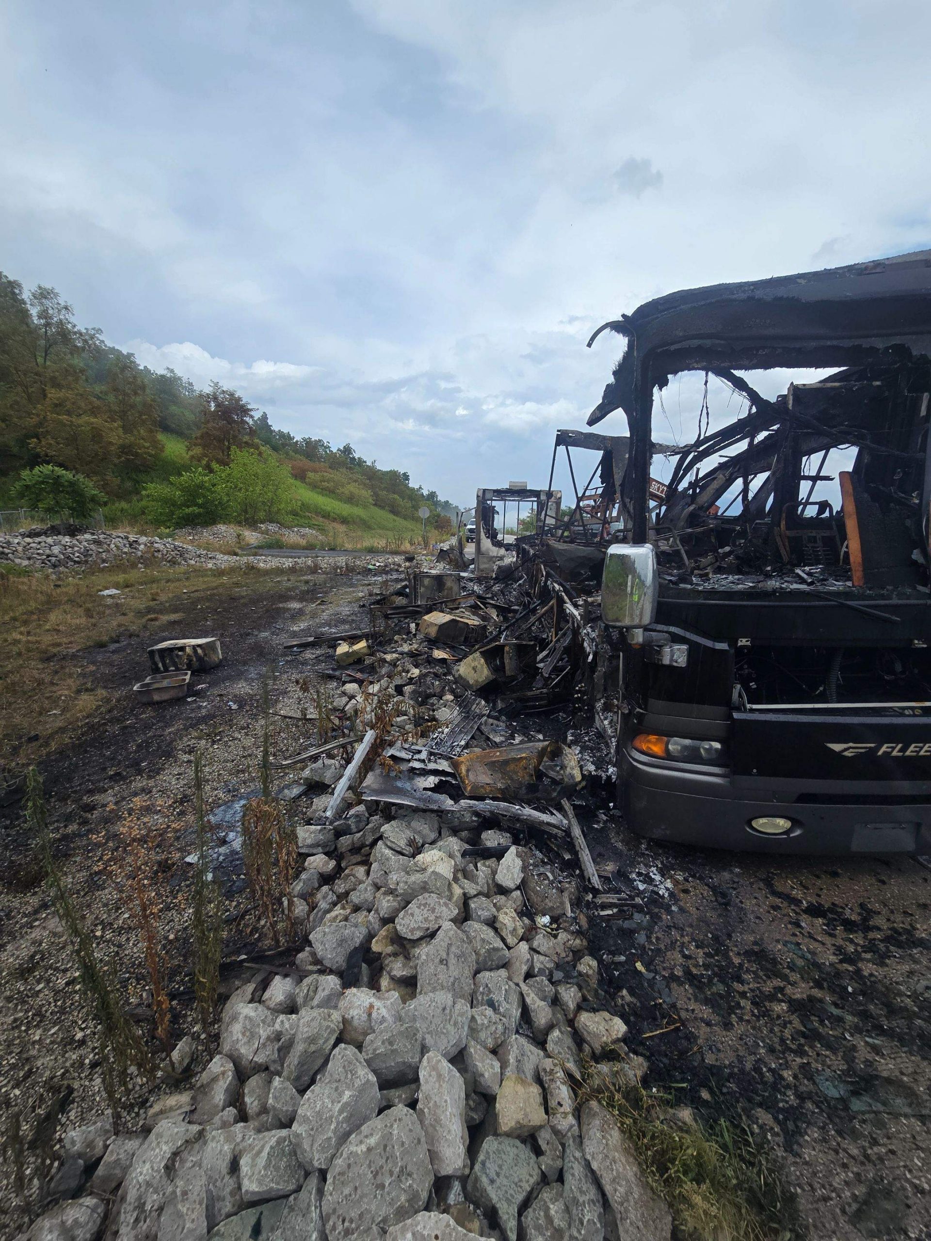 Severely fire-damaged bus along the roadside