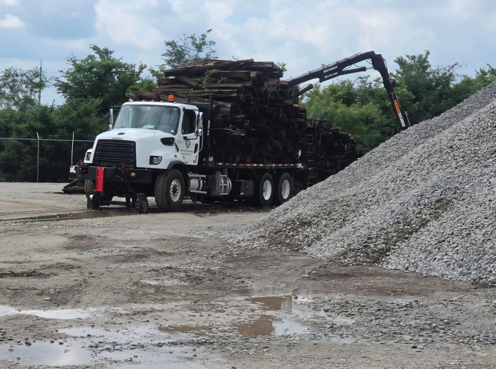 C2G hi-rail grapple truck hauling a full load of railroad ties