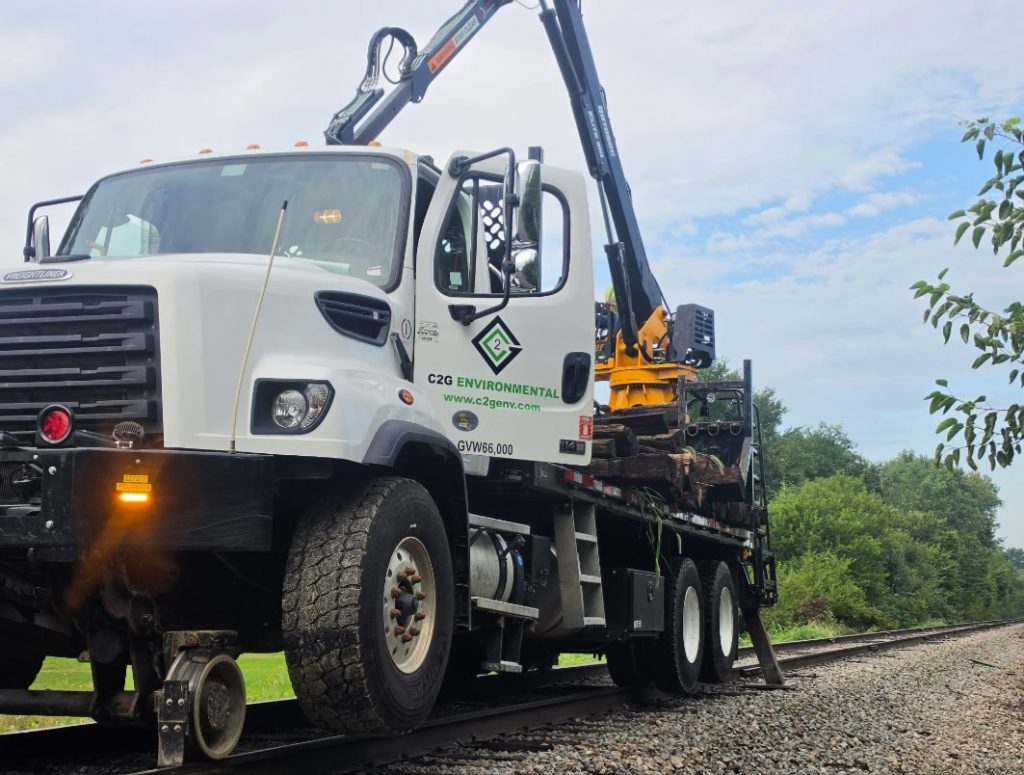 C2G hi-rail grapple truck with rail wheels and stabilizer deployed