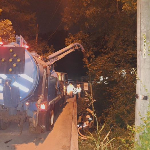 C2G crew cleaning a waterway beneath a bridge during nighttime spill response