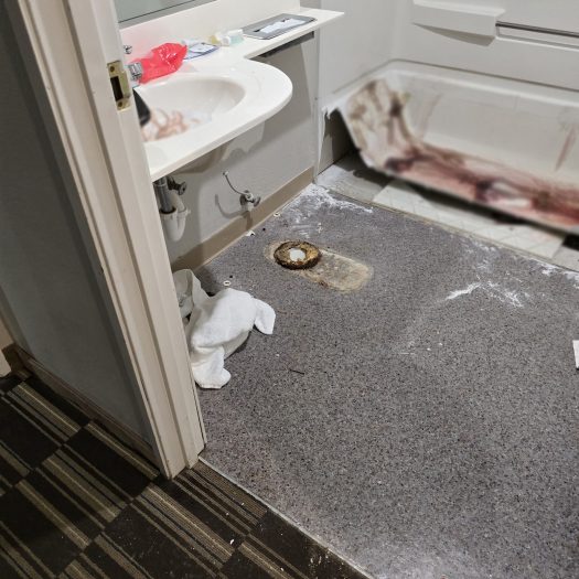 Bathroom undergoing blood cleanup with bathtub and toilet removed for bio-remediation