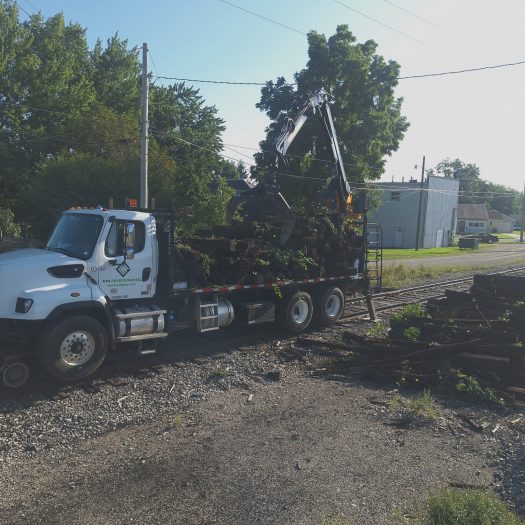 C2G hi-rail grapple truck loaded with used railroad ties