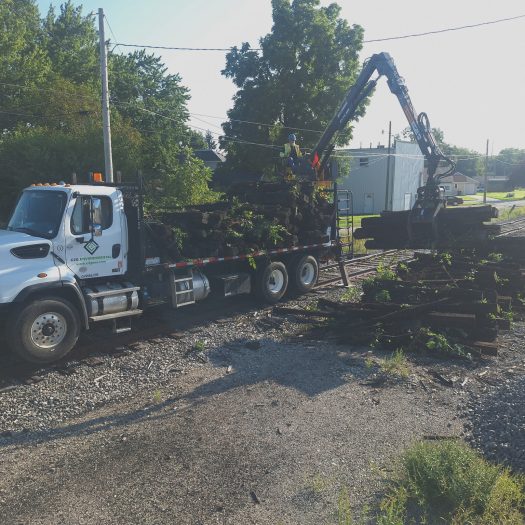 C2G hi-rail grapple truck picking up used railroad ties