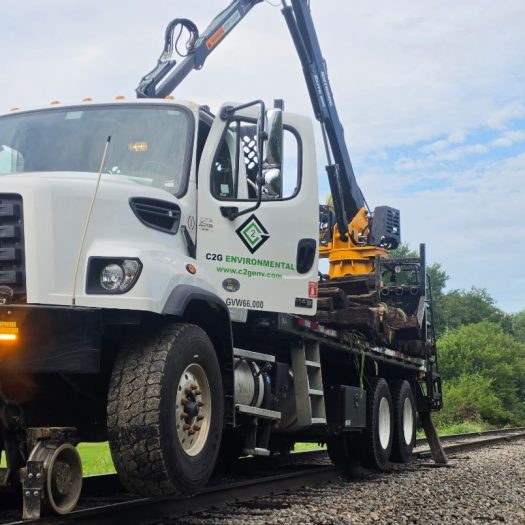 C2G hi-rail grapple truck with rail wheels and stabilizer deployed