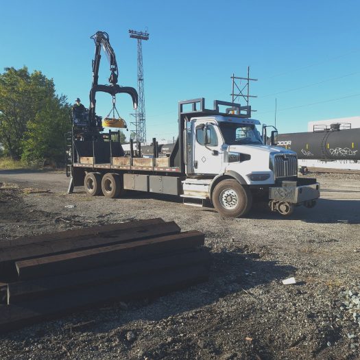 C2G grapple truck performing railroad material handling at rail yard