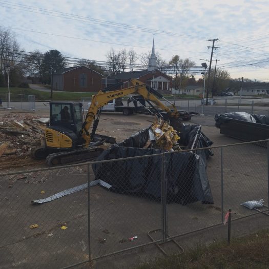 C2G Environmental technician moving asbestos riddled rubble into plastic lined container