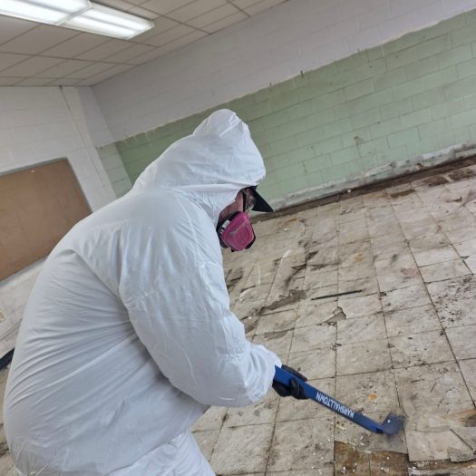 C2G Environmental technician removing asbestos floor tile