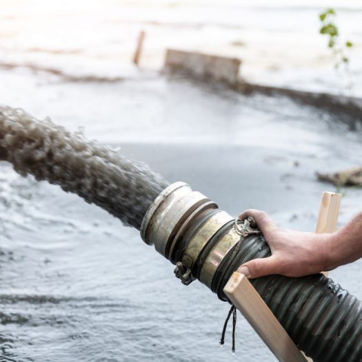 Large corrugated hose pumping floodwater away during water removal