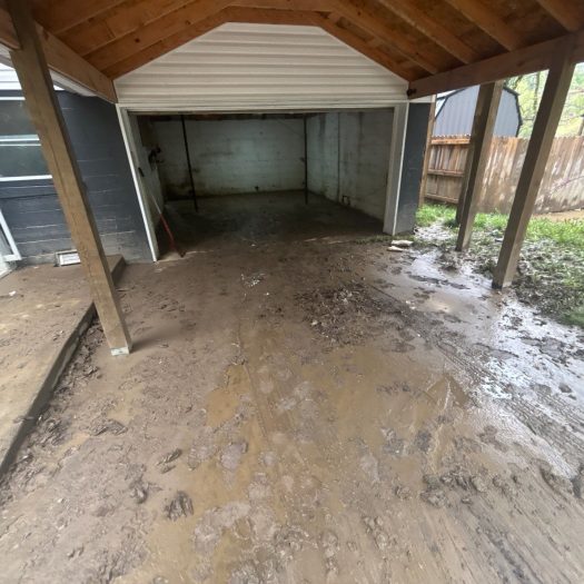 Mud-covered garage after C2G flood damage cleanup and debris removal