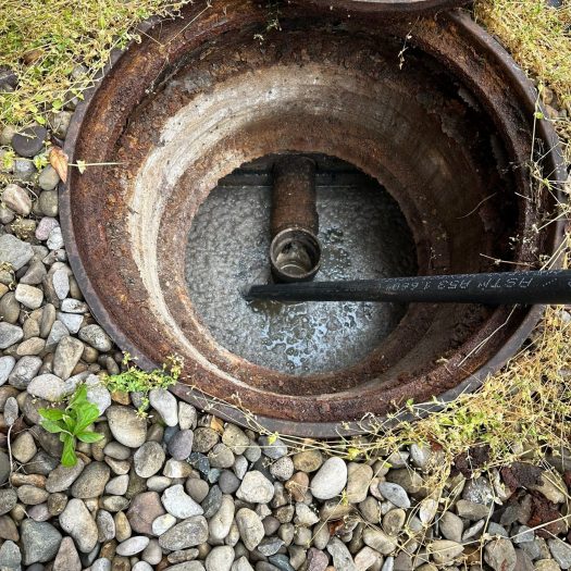 Pressure jetting hose submerged in a clogged sewer line during cleaning