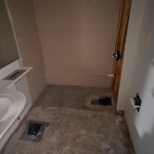 Bathroom after blood cleanup with bathtub flooring and damaged drywall removed